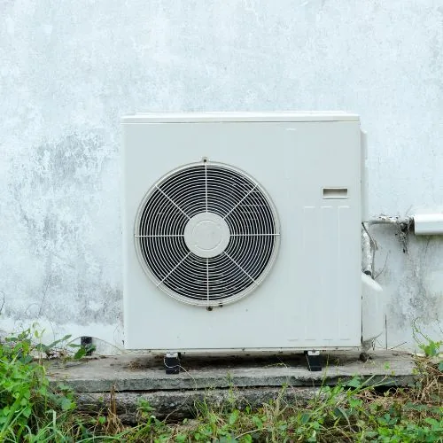 Unité extérieure d'une pompe à chaleur air-air installée le long d'un mur